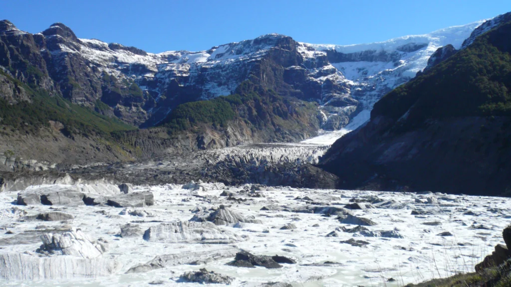 Frente de glaciar y paredes nevadas del cordón del Tronador sobre el valle de roca.