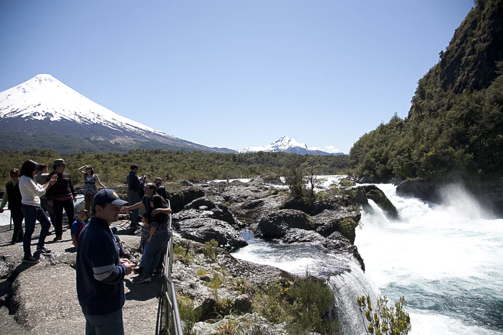 Visitantes en el mirador de los Saltos de Petrohué con el volcán Osorno nevado detrás.