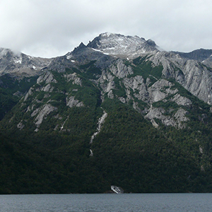Paredes de roca y cumbres nevadas cayendo sobre el lago, en el cordón del Tronador.