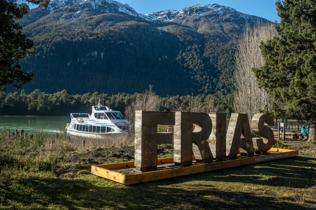 Placa indicativa do Lago Frías no Parque Nacional Nahuel Huapi, com o barco atracado na margem.