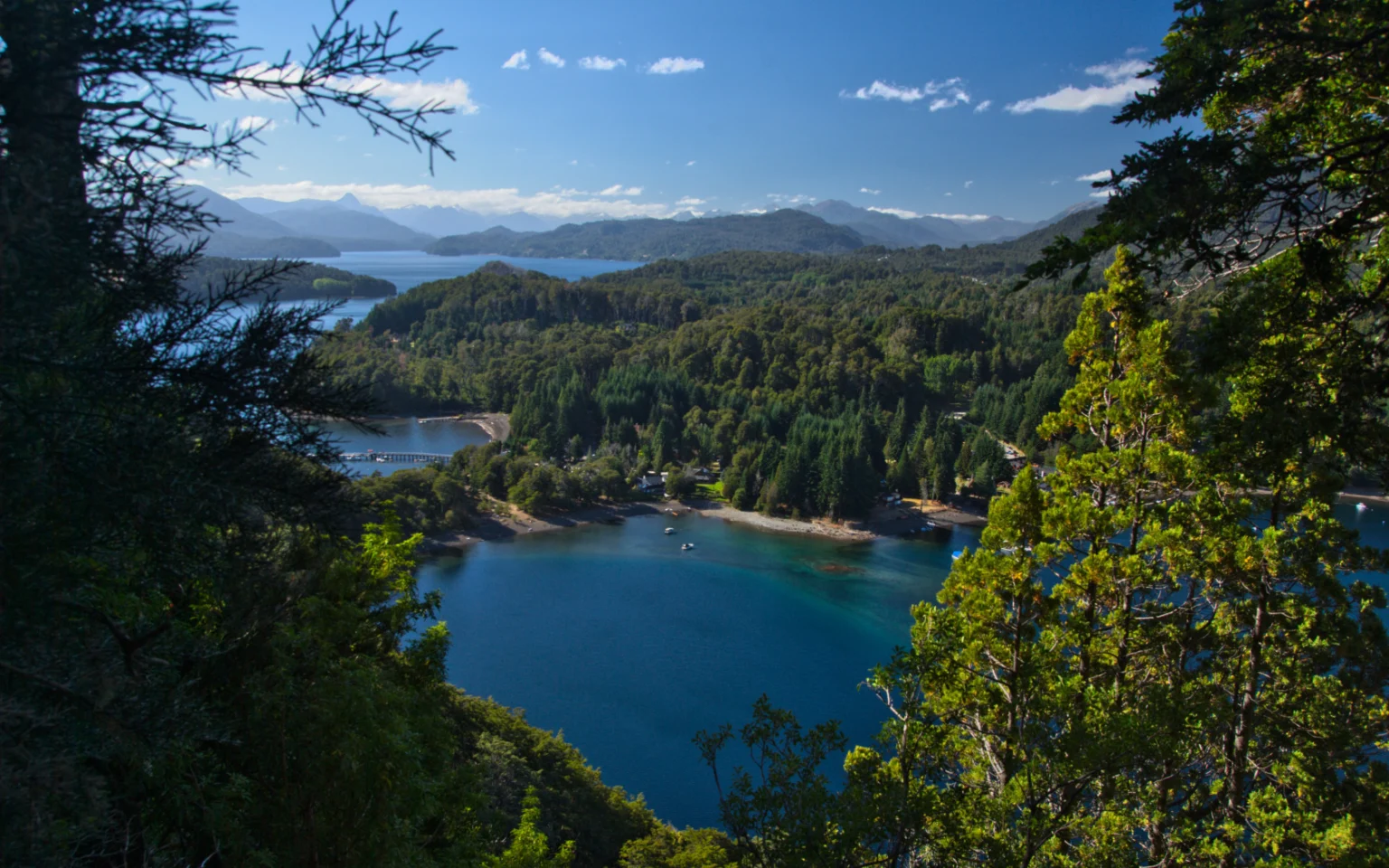 Bahía de aguas turquesas del lago Nahuel Huapi vista desde un mirador entre el bosque, cerca de Villa La Angostura.
