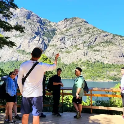 Guía de turismo señalando el cerro López a un grupo desde una pasarela del Circuito Chico en Bariloche.